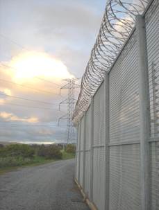 A view of the sun breaking through the clouds outside of a correctional facility.